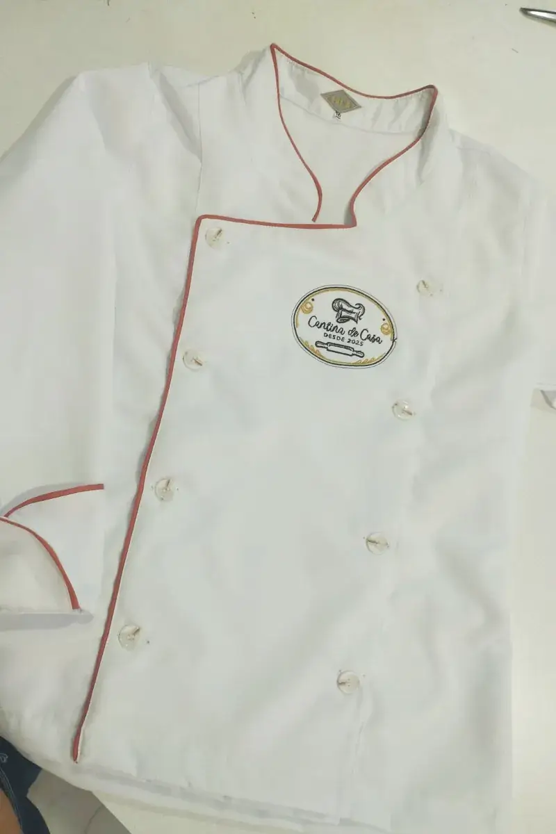 Dólmã branca com viés rosa e logomarca de restaurante bordada