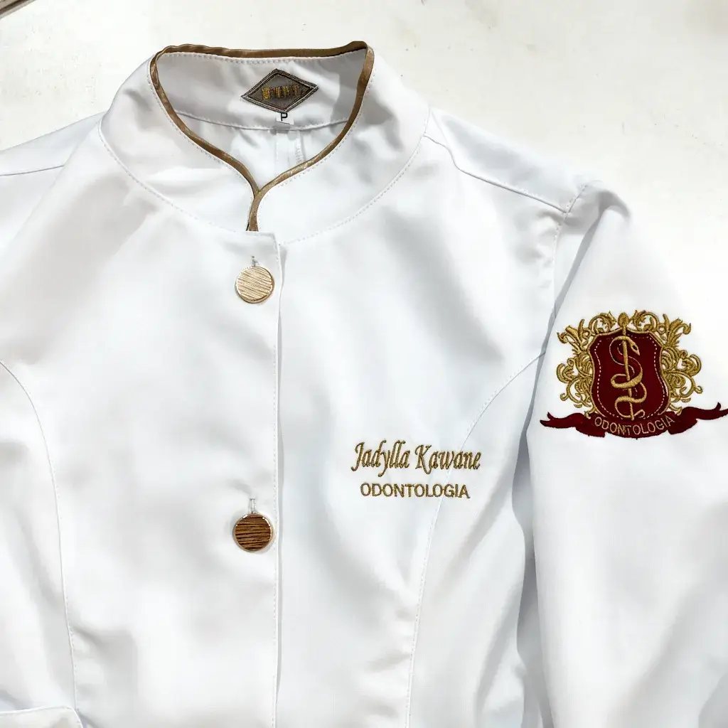 Jaleco branco com gola padre e botões dourados, nome, Odontologia e brasão bordados